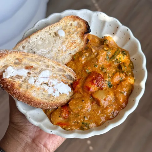 Harissa butter beans on a plate with toast.
